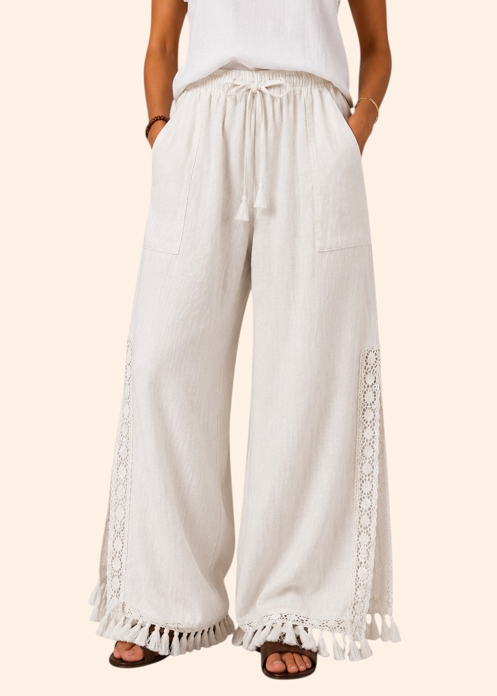 Zeemara white wide-leg pull-on pants featuring side crochet panels, deep pockets, and a fringed tassel hem.
